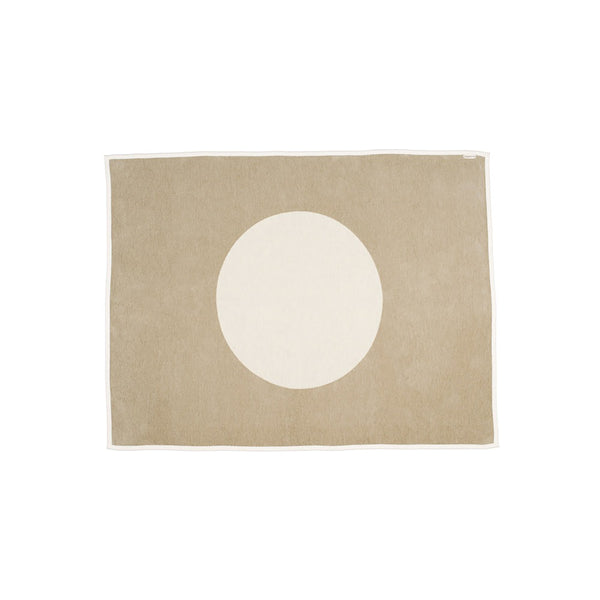 A soft, large-sized beige lambswool and cotton blend throw blanket with a vanilla white circle in the middle and hemmed edges in the same white. 