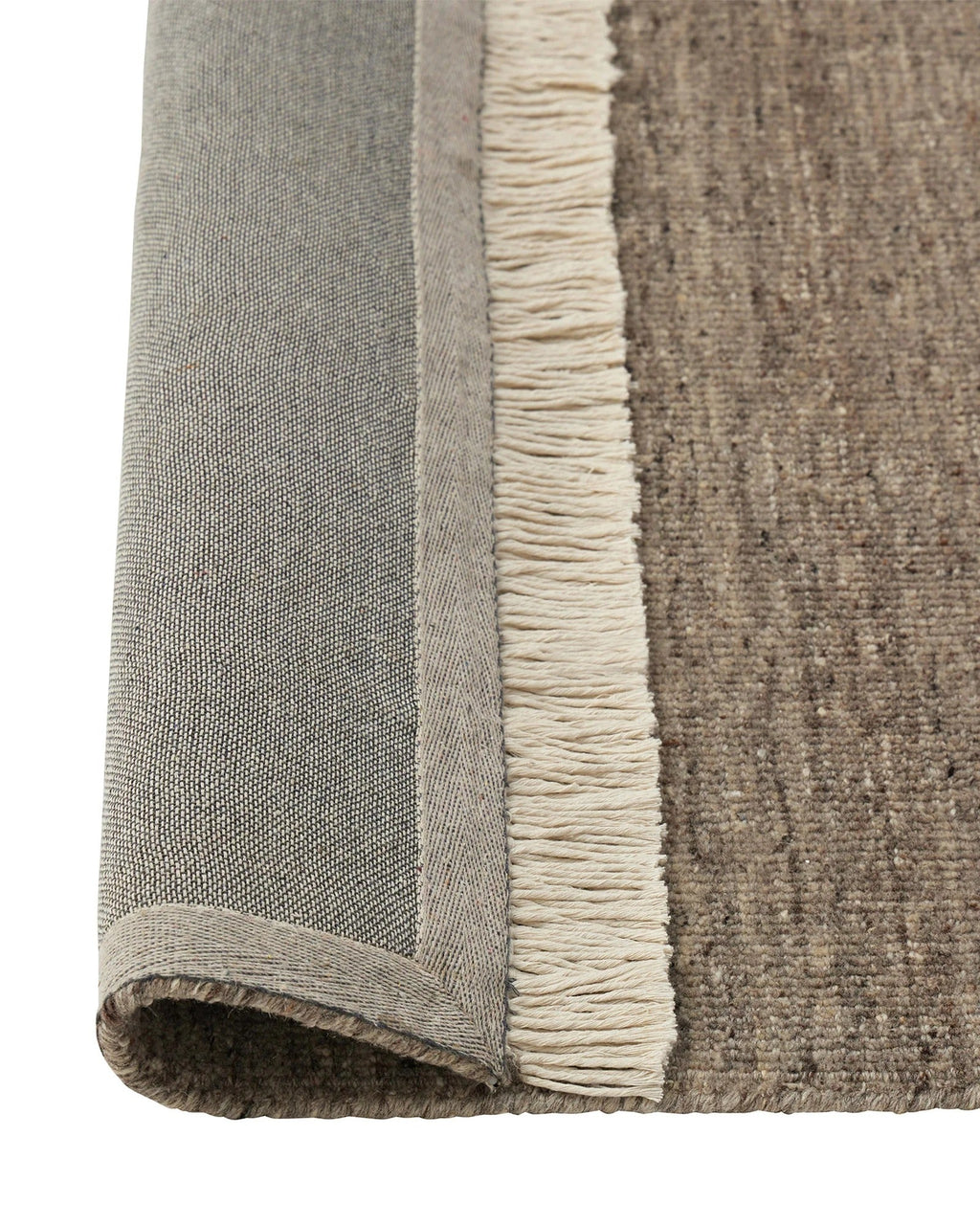 Weave Home Anton wool rug in Ash folded back to show the cotton backing and cream fringe