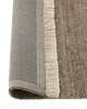 Weave Home Anton wool rug in Ash folded back to show the cotton backing and cream fringe