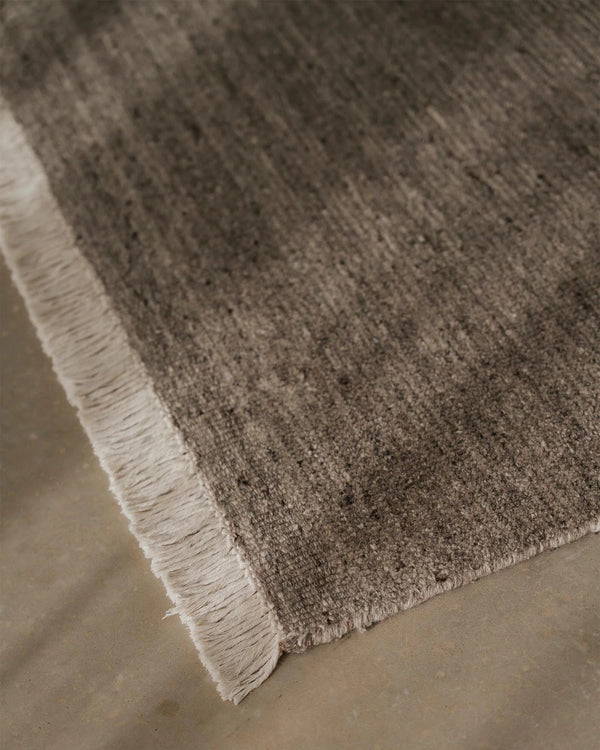 Weave Home Anton wool rug in Ash, close view of the cut and loop pile and cream cotton fringe