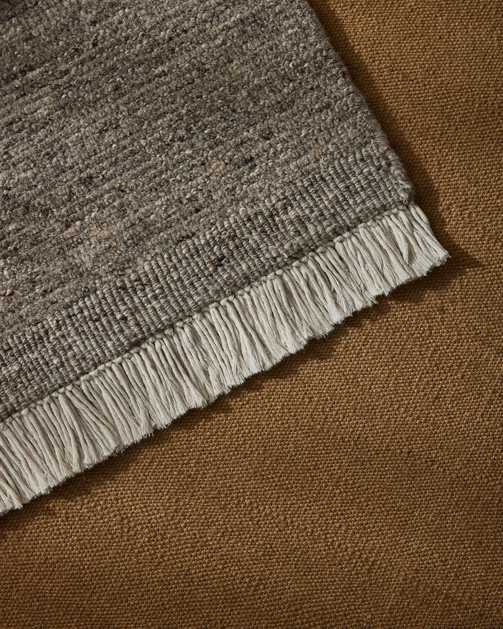 Weave Home Anton wool rug in Ash layered over a tan rug