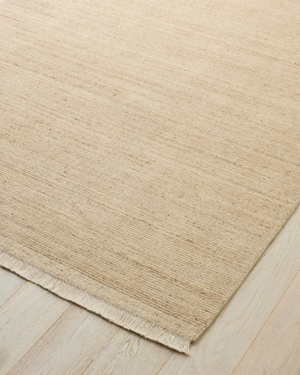 Weave Home Anton wool rug in Sand on a pale timber floor