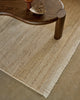 Weave Home Anton wool rug in Sand beneath a curved timber coffee table, close view of the pile and fringe