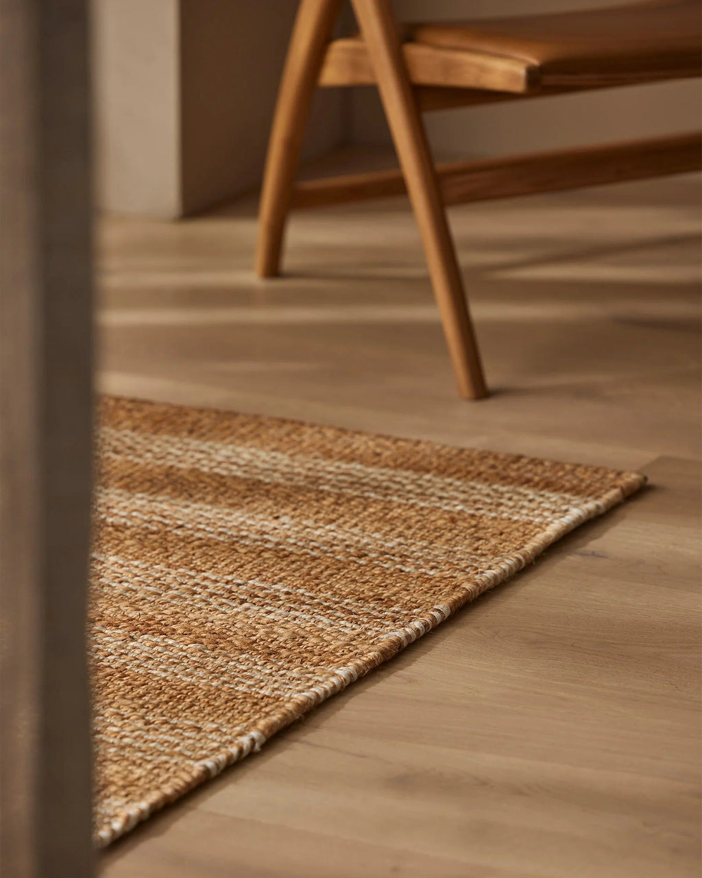 Weave Home Arden Jute Doormat in Natural placed near a timber chair
