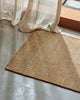 Weave Home Ivano jute doormat in Wheat at the base of a timber staircase.