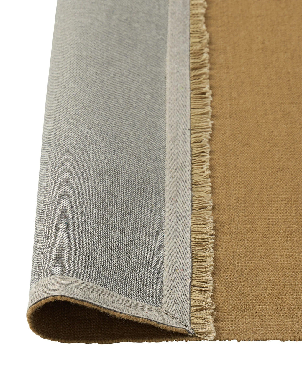 Weave Home Jacqueline wool rug in Brulee, folded corner showing the cotton backing and fringed edge.