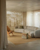 Weave Home Jacqueline wool rug in Brulee, styled in a living room with a sofa and timber armchair.