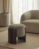 Weave Home Jacqueline wool rug in Cashew, styled with an upholstered stool beside a curved armchair