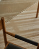 Weave Home Jacqueline wool rug in Cashew, close view of the flatweave and fringed edge on a stone floor