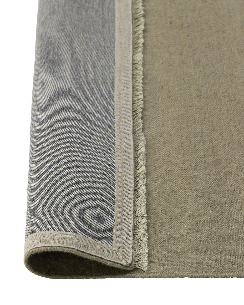 Weave Home Jacqueline wool rug in Pumice folded back to show the backing and fringe