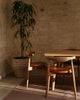 Weave Home Jacqueline wool rug in Rosewood in a sunlit room with a potted tree and timber chairs