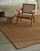 Weave Home Monroe jute rug in Biscuit with a cane armchair and a small burl side table