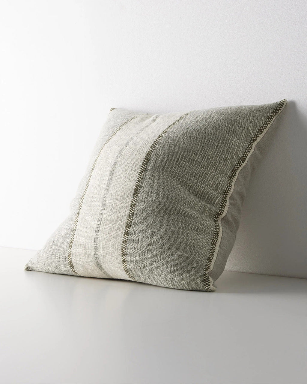 Weave Home Ottavio cushion in Lagoon, shown from an angle on a plain background.