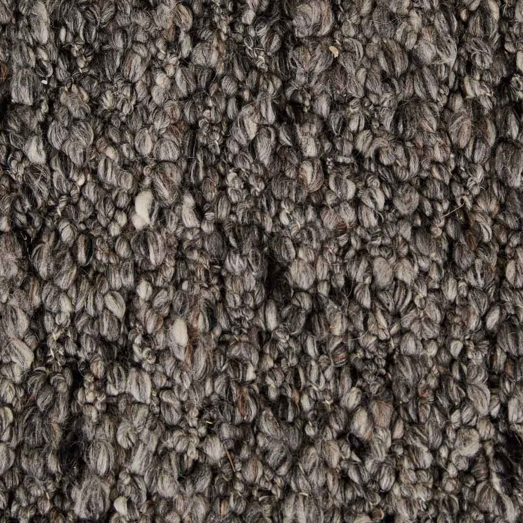 Close up of the weave of a  textural wool blend boucle style rug by Globe West and Soren Liv NZ in shades of grey and charcoal.