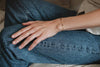 A woman wearing a gorgeous delicate and sophisticated gold-fill chain style bracelet with black agate beads