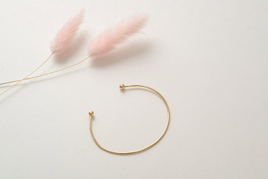The Denmark bangle bracelet, made with yellow-gold fill and hammered into a beautiful minimalist cuff shape. 
