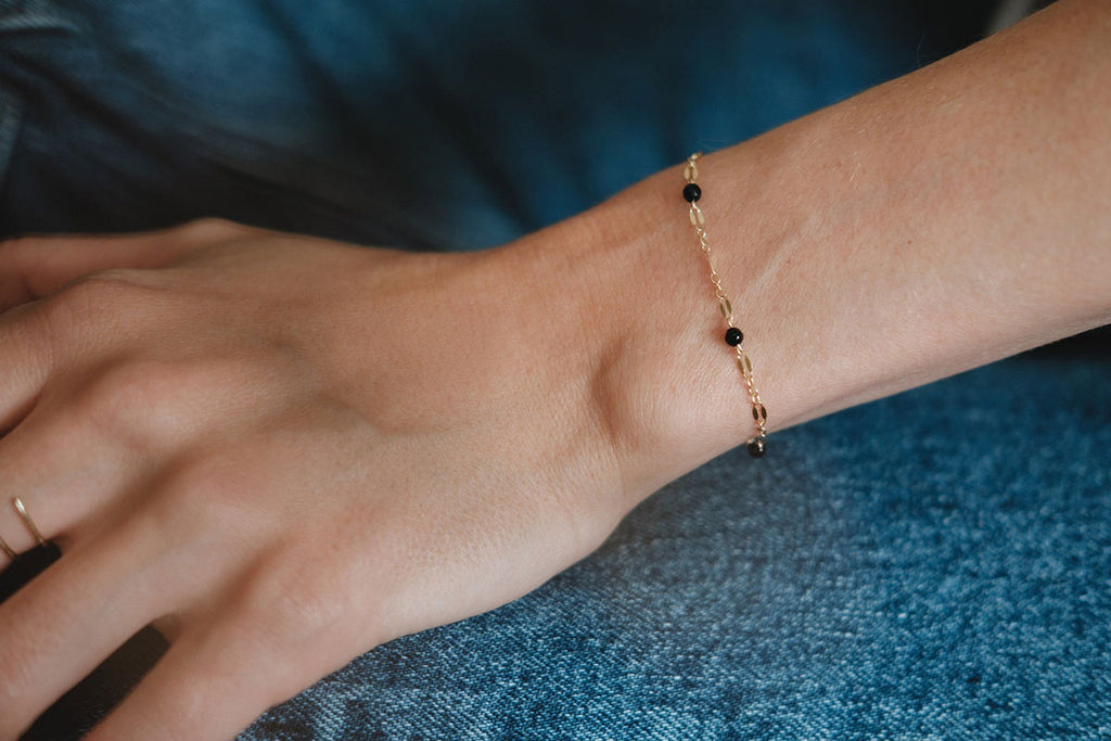 A delicate chain link bracelet with black agate beads. 