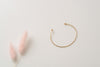 A minimalist gold-fill bangle with balls on the ends, and an adjustable fit, by Zoaje. 