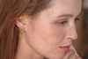 A woman wearing Zoaje's designer jacket stud earrings in yellow gold. 