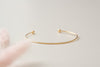 A beautiful hammered gold-fill bangle, lying on it's side. 