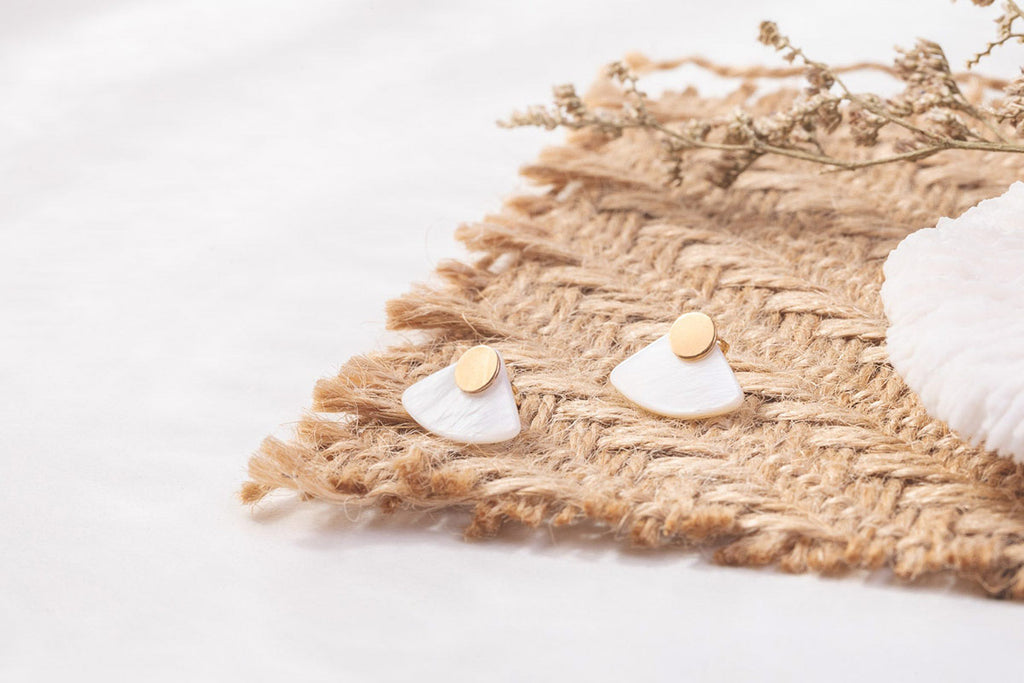 Zoaje designer earrings, displayed on a grass mat, to showcase the textures of the earring. 