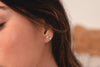 A woman wearing the Zoaje stud earrings. They sit beautifully on her earlobe, the starburst pattern catching the light. 