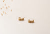 The Rouen earrings by Zoaje lying on their side to better view the texture of the gold. 