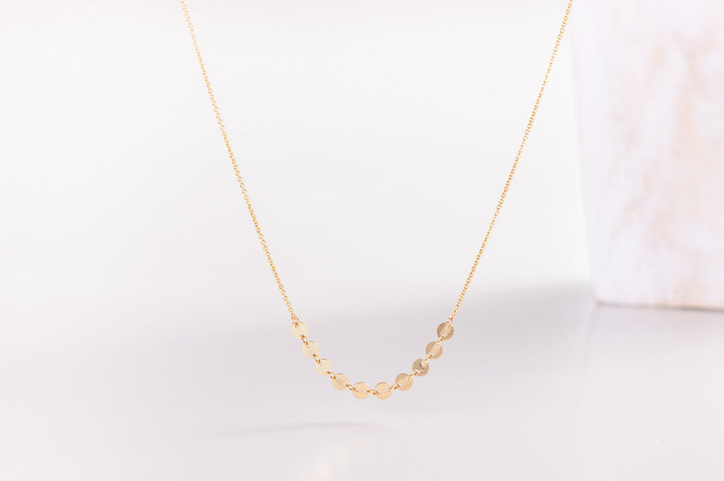 A view of the Italy necklace by Zoaje, in yellow gold fill with ten beautiful charms along a delicate chain. 