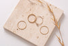 The Malaysia ring stack, seperated and viewed from above. The geometric textuality of the hammered gold rings contrasts with the simple delicacy of the feature stone ring. 