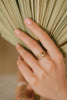 A woman's hand wearing the Malaysia ring stack, a set of four beautiful gold-fill rings. 