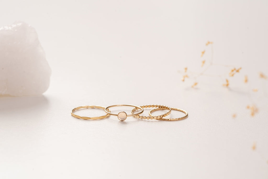 A side view of the rings that make up the Malaysia ring stack by Zoaje. The yellow gold-fill and natural white agate compliment the textures of the rings. 