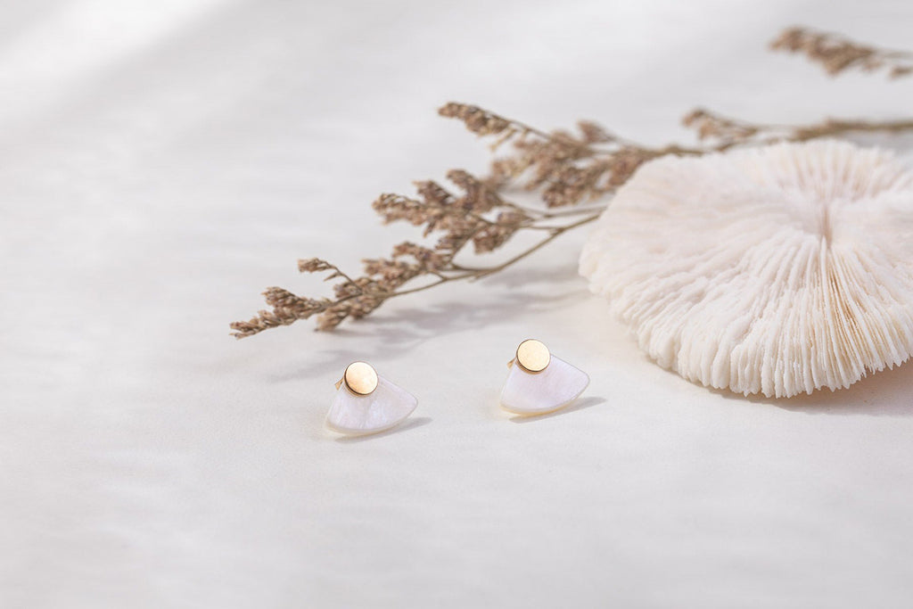 The Ghana stud earrings by Zoaje, featuring yellow gold and mother-of-pearl accenting. 