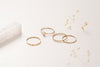 The Zoaje Malaysia ring stack, separated into different rings. The hammered gold glints in the light and the unique textures of the rings compliment each other. 