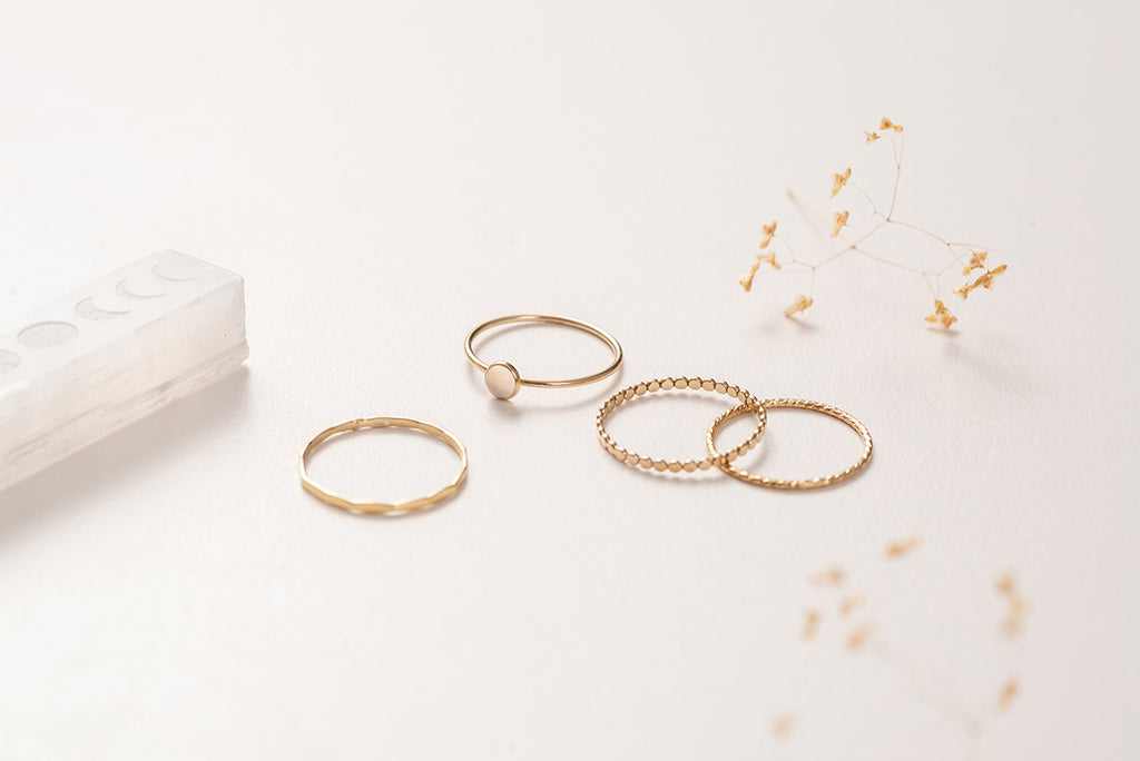 The Zoaje Malaysia ring stack, separated into different rings. The hammered gold glints in the light and the unique textures of the rings compliment each other. 