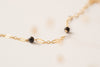 A close up of the Rouen bracelet, a delicate chain with black agate beads interspersed. 