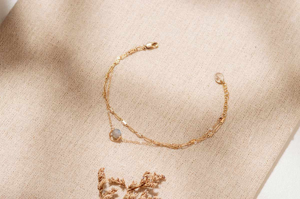 A beautiful bracelet in yellow gold chain link with an intricate charm of labradorite crystal in the centre. 