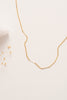 A fine delicate gold chain necklace with flattened sections giving texture. 