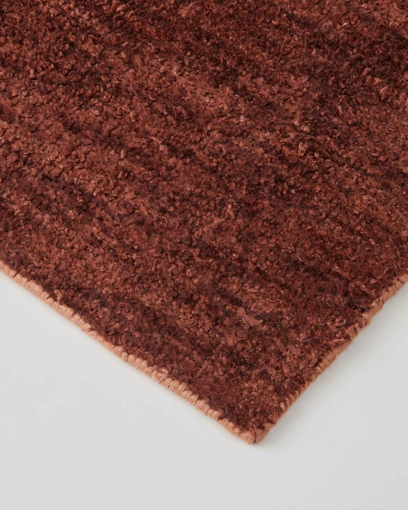 A close up of the Almonte Clay rug by Weave Home nZ showing its earthy red colour and subtle texture