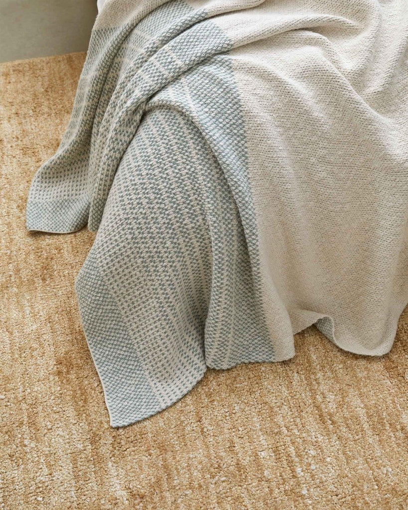 The textural Almonte floor rug in colour honeycomb, seen under a bed