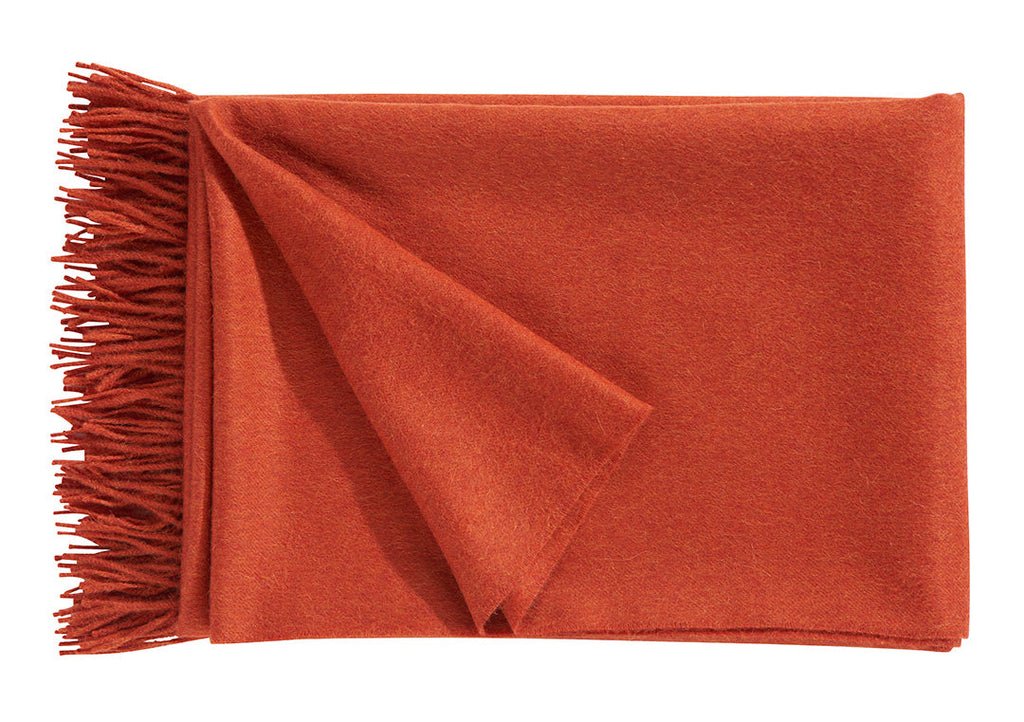 A luxurious Christian Fischbacher throw, made from soft warm alpaca yarn, and in a striking coral rusty-orange colour