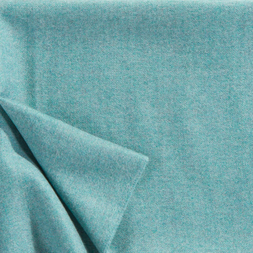 A close up of a luxurious Christian Fischbacher throw, made from soft warm alpaca yarn, and in a stunning aqua blue shade