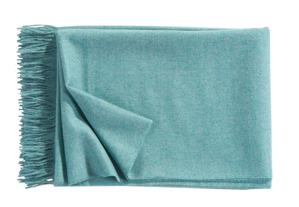 A luxurious Christian Fischbacher throw with fringe detail, made from soft warm alpaca yarn, and in a stunning aqua blue shade