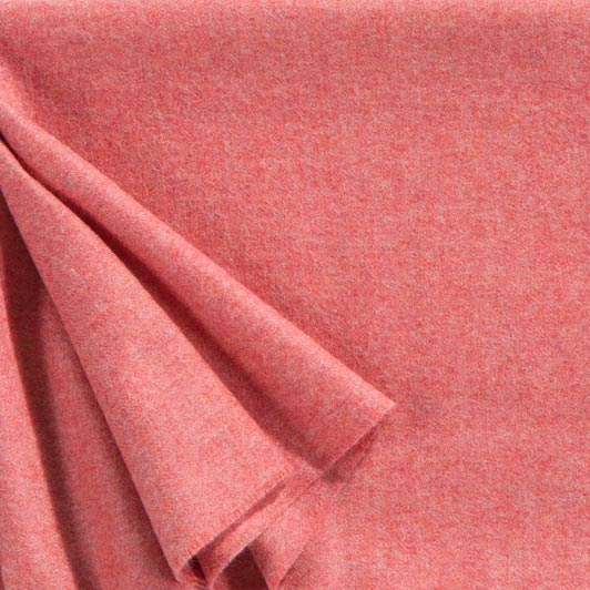 A close up of a luxurious Christian Fischbacher throw, made from soft warm alpaca yarn, and in a stunning watermelon blush pink shade