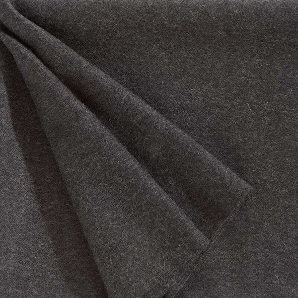 A close up of a luxurious Christian Fischbacher throw, made from soft warm alpaca yarn, and in a versatile charcoal grey