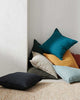 Jewel toned linen cushions piled and stacked in the corner of a room interior, Weave Home NZ