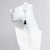 Model wearing simple, elegant gold and black dangle earrings by David Aubrey