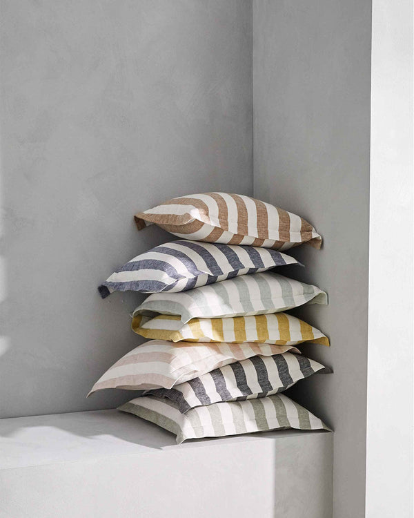 A stack of linen cushions with flange detail, featuring large stripes in on-trend colours; by Weave Home NZ