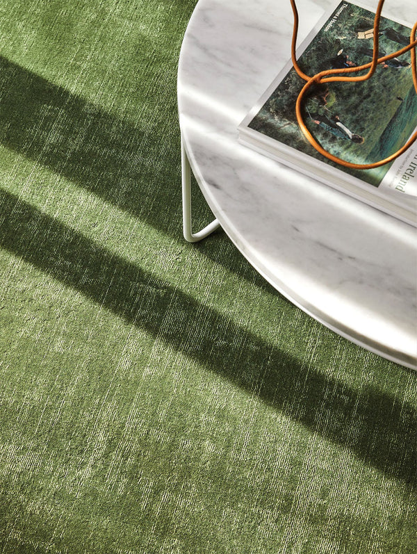 The Tribe Home NZ Tait wool rug in green colour watercress, seen under a coffee table