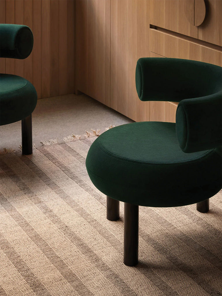The Tribe Home nz Magnus rug shown in a timber room with green chairs