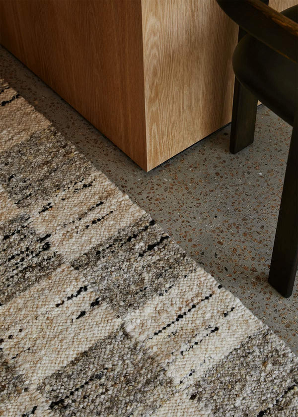 The Trube Hoome NZ Harvest natural wool rug seen close up on the floor next to a chair